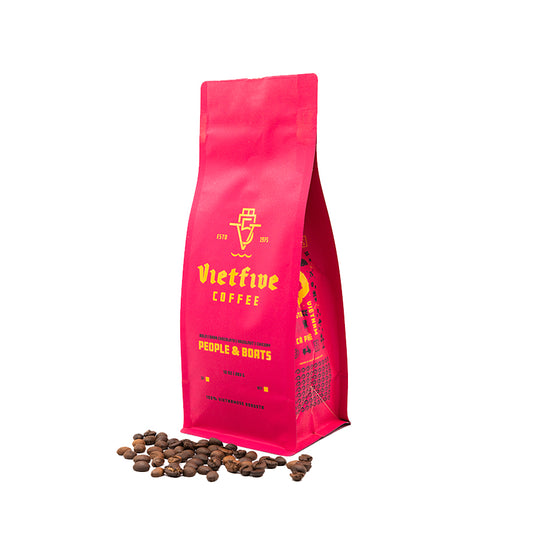 A red bag of VietFive Dark Roast coffee beans with some beans scattered in front.

